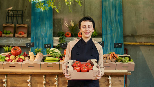 Portrait of young woman with vegetables at market