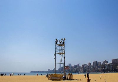 People on beach against clear sky