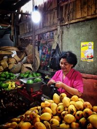 Woman with fruits for sale at market stall