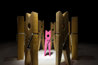 Close-up of clothespins on table against black background