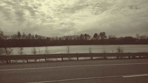 Scenic view of river against cloudy sky