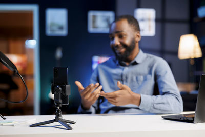 Portrait of young man using mobile phone in office