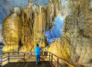 Rear view of man standing in cave