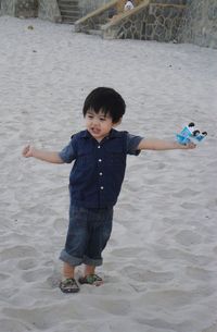 Cute boy playing on sand at beach