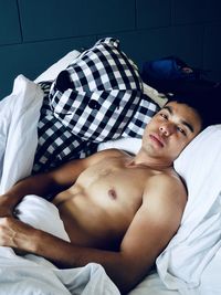 Young man lying down on bed