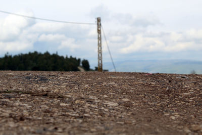 Surface level of electricity pylon on land against sky