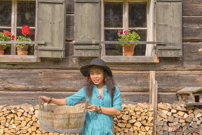 Portrait of smiling young woman standing on wood