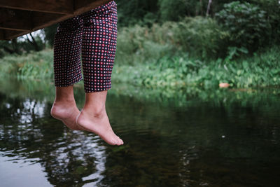 Low section of person standing by lake