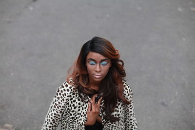 Young woman with eye make-up on road