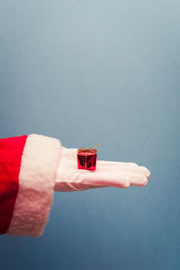 Close-up of hand holding flag against white background