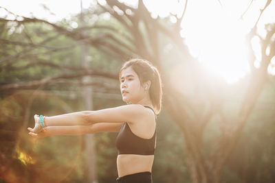 Portrait of young woman exercising in forest