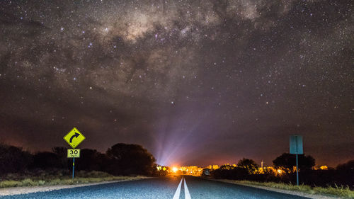 Road sign against sky at night
