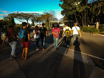 Rear view of people walking on street in city