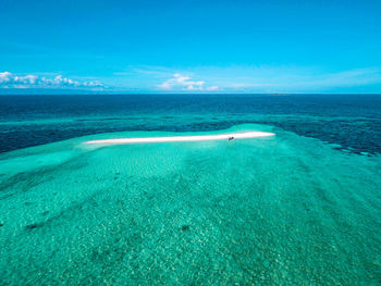 Scenic view of beach against blue sky