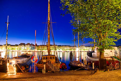 Boats moored in canal at night