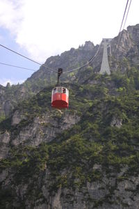 Overhead cable car over mountains against sky