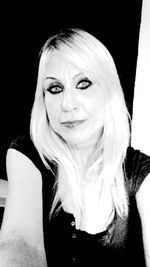 Portrait of smiling young woman against black background