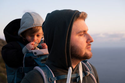 Father with baby on back against sky