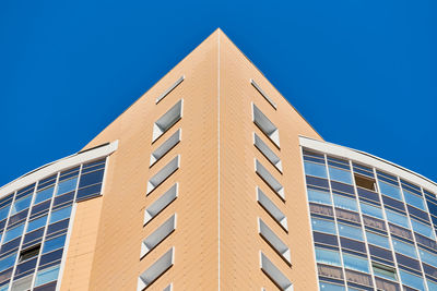 Low angle view of modern building against clear blue sky