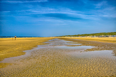 Scenic view of beach against blue sky