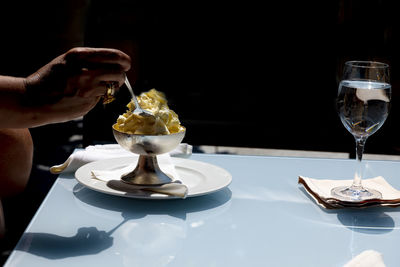 Hand holding ice cream on table
