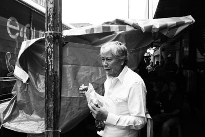 Man holding camera while standing outdoors