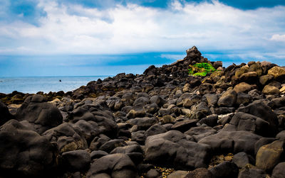 Scenic view of rocks on beach against sky