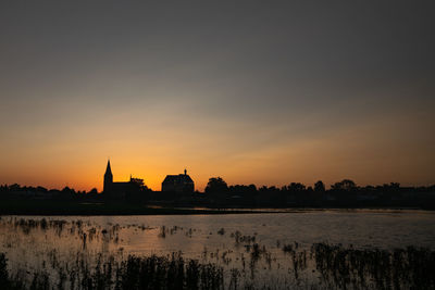 Silhouette of buildings against sky during sunset