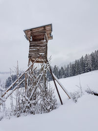 Built structure on snow covered field against sky