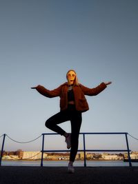 Full length of woman standing against clear sky