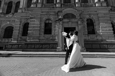 Rear view of woman standing outside historic building