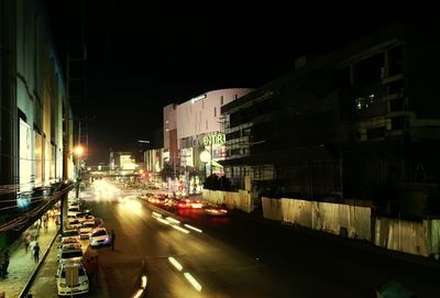Cars on street amidst buildings in city at night