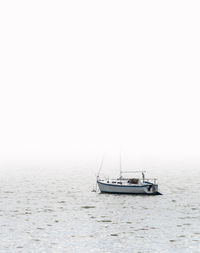 Sailboat sailing on sea against clear sky