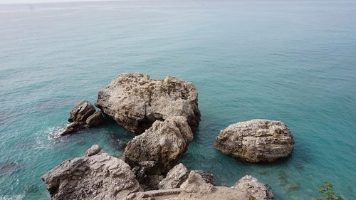 High angle view of rocks in sea against sky