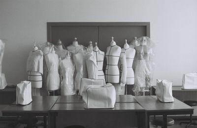 Mannequins and table against wall in room