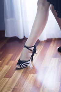 Low section of woman standing on hardwood floor