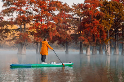 Rear view of man kayaking in lake