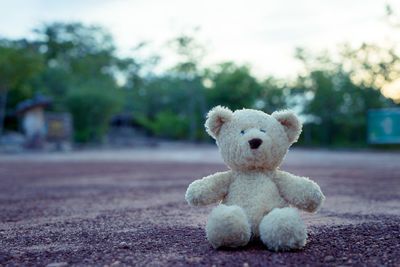 Close-up of stuffed toy on road against sky