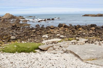 Rocks on beach against sky