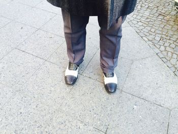 Low section of man standing on pavement