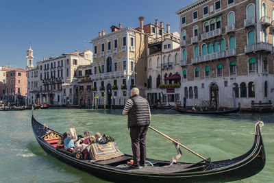 Rear view of man on boat in canal