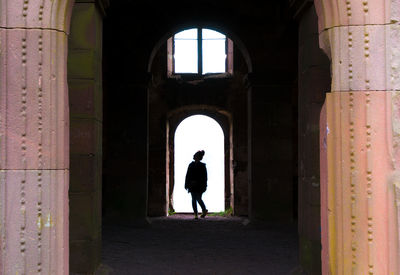 Silhouette woman walking in doorway of historical building