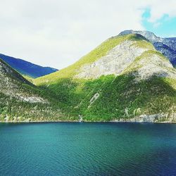 Scenic view of sea and mountains against sky