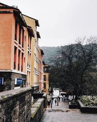 Buildings by street against sky