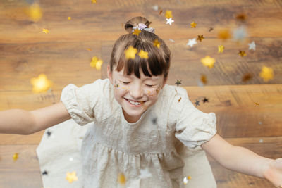 Portrait of a pretty girl with star-shaped sequins on her face. the girl smiles. fun holiday