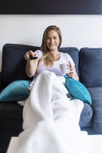 Young woman sitting on sofa at home