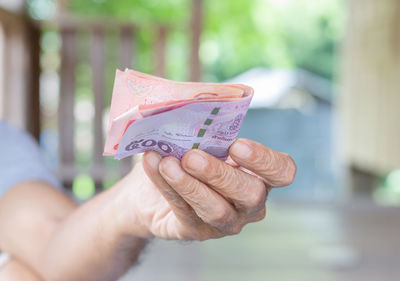 Close-up of hand holding paper