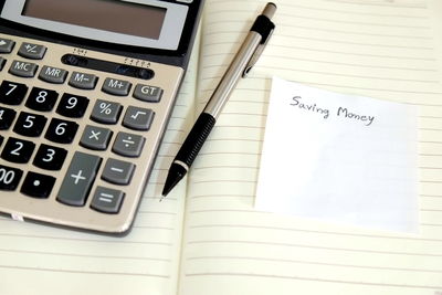 High angle view of pen with note and calculator on diary