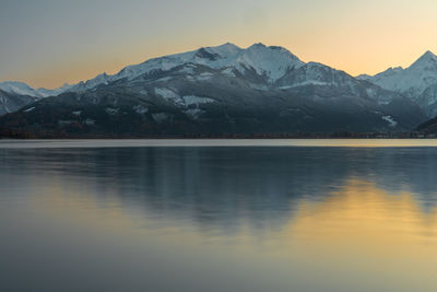 Scenic view of lake and mountains against sky during sunset