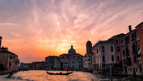 Sunset over the city of venice. silhouette of a gondola in a canal.